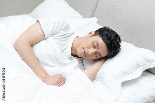 A young Asian man is resting