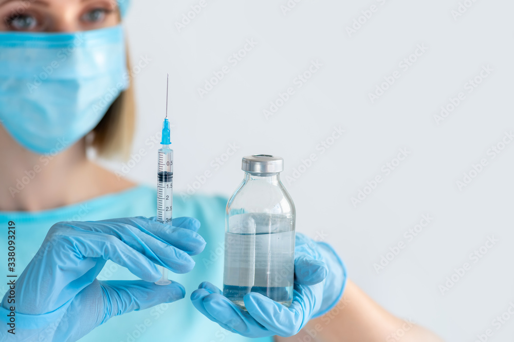 Medicine bottle and syringe for injection in nurse hand. Medical glass vial for vaccination. Science equipment, liquid drug or vaccine. Medicine concept Medicine bottle and syringe for injection in nurse hand. Medical glass vial for vaccination. Science equipment, liquid drug or vaccine. Medicine concept