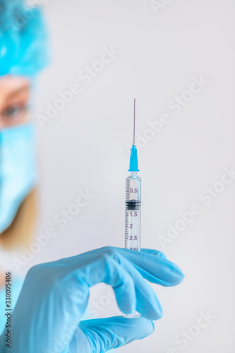 Syringe for injection in nurse hand. Medical glass vial for vaccination. Science equipment, liquid drug or vaccine