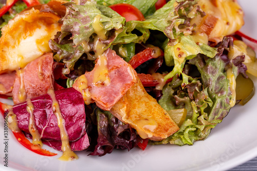 Salad with bacon, pickles, cherry tomatoes, sweet pepper and mustard sauce