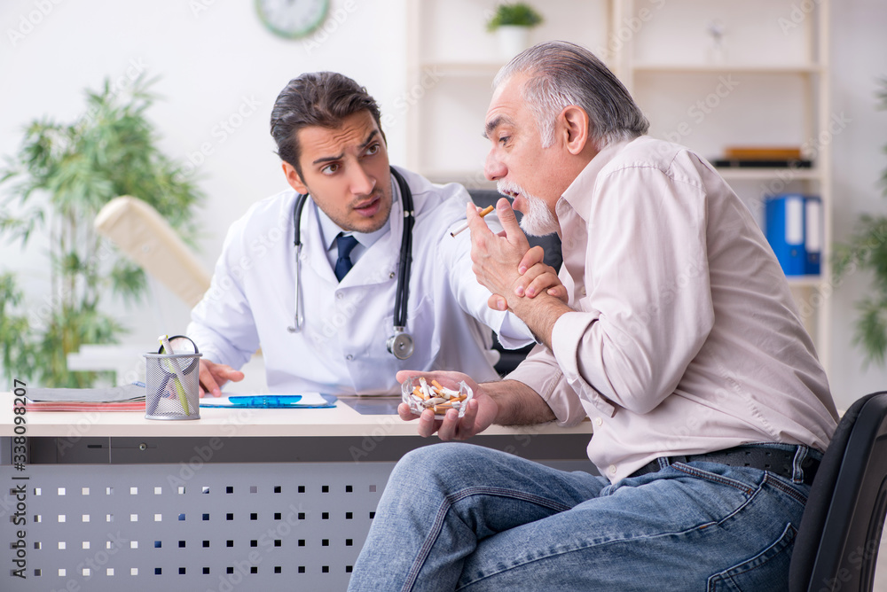 Obraz premium Young male doctor and old patient in antismoking concept