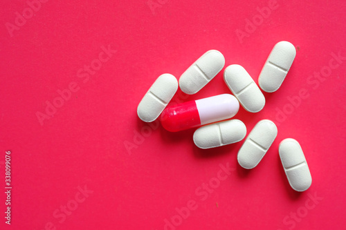 high angle view of white pills and capsule on color background 