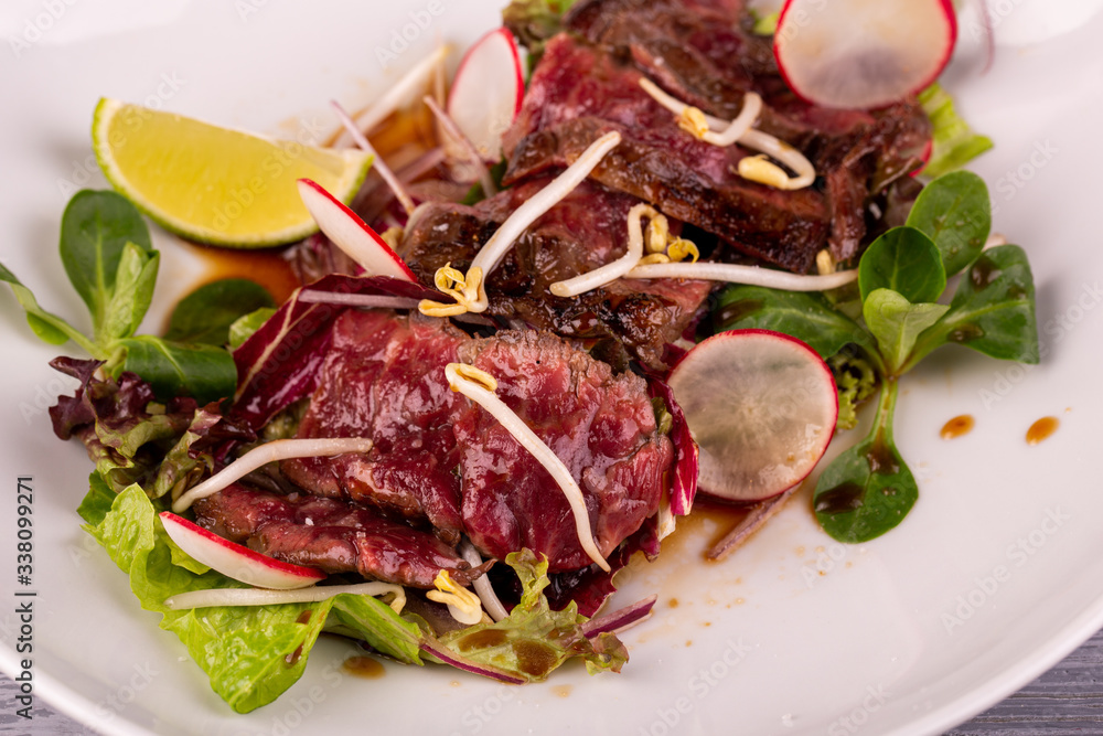 Warm beef salad with terriaki sauce, served with radish, lime and fresh salad Warm beef salad with terriaki sauce, served with radish, lime and fresh salad