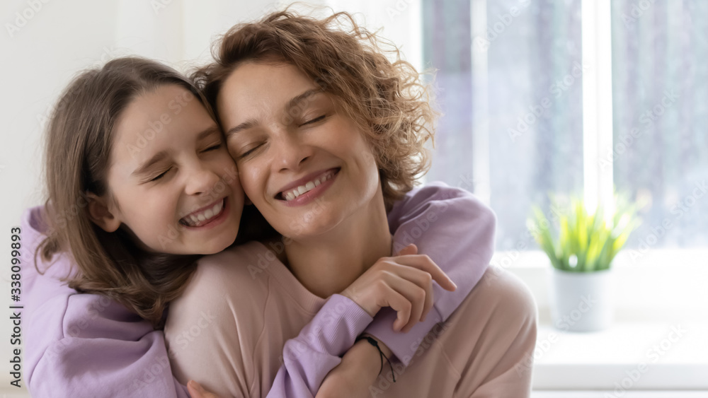 Cute happy teenage daughter embracing loving young mama at home. Affectionate teen child girl and adult mommy hugging enjoying tender sweet moment of mother and child love, feeling gratitude concept. Cute happy teenage daughter embracing loving young mama at home. Affectionate teen child girl and adult mommy hugging enjoying tender sweet moment of mother and child love, feeling gratitude concept.