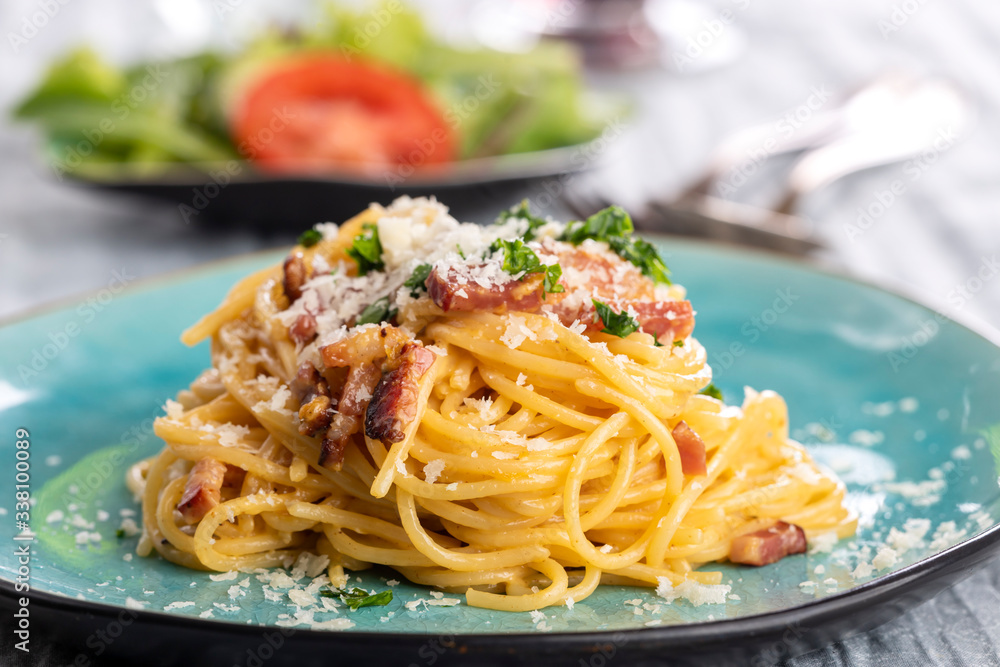 spaghetti carbonara on a blue plate spaghetti carbonara on a blue plate