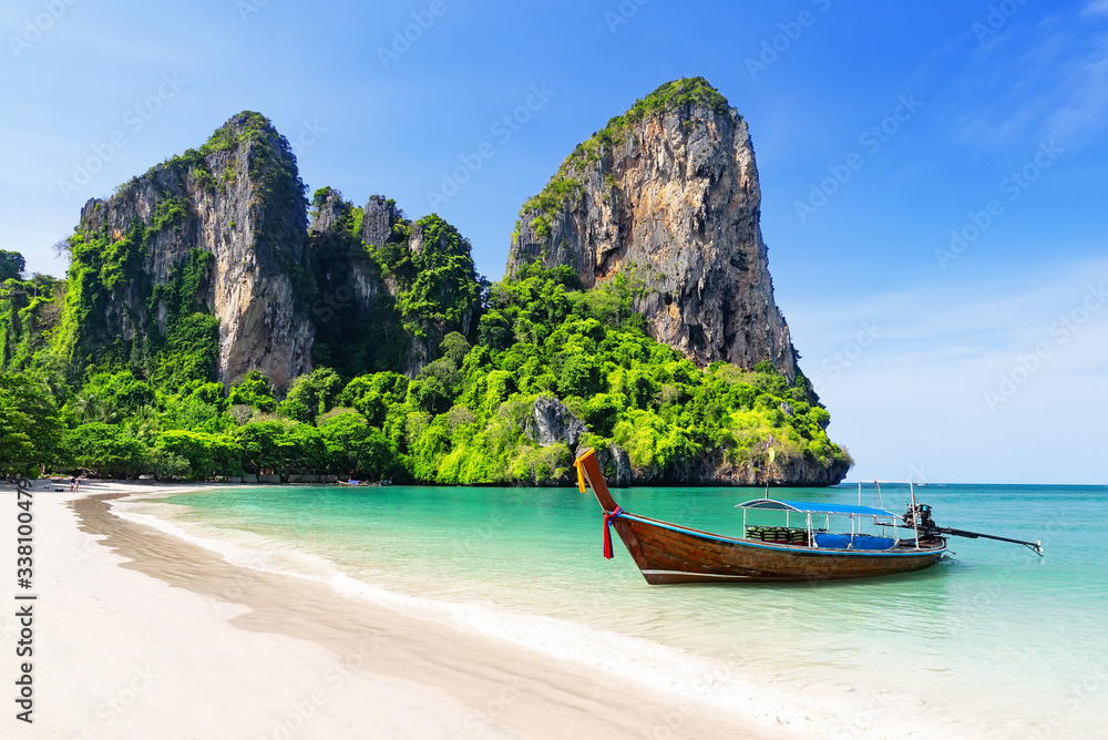 Thai traditional wooden longtail boat and beautiful sand beach.