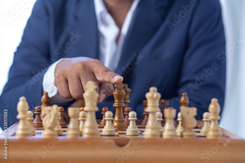 Businessman hand moving of playing chess strategy concept: symbol confident new strategy plan for win and success, sports game thinking battle planning object achievement queen for successful 