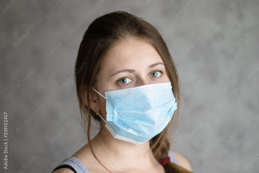 Beautiful young woman wearing face mask because of air pollution, coronavirus or flu. Girl in the medical surgical mask for face protection. Method of preventing an epidemic or pandemic of the virus Beautiful young woman wearing face mask because of air pollution, coronavirus or flu. Girl in the medical surgical mask for face protection. Method of preventing an epidemic or pandemic of the virus