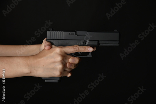 Fotografie Man pointing gun ready to shoot, Killer with 9mm handgun pistol waiting for robbing the victim, Weapon and violence crime concept