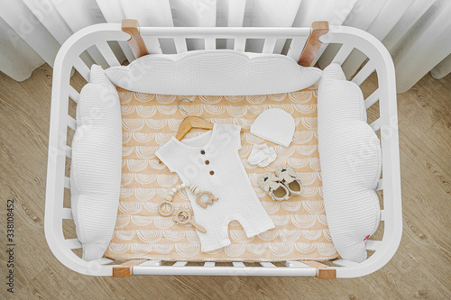 Bilde på lerret The top view of baby clothes and accessories in cot, cradle