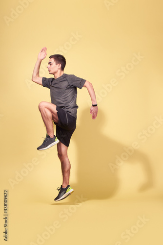 Side view of athlete man running in studio