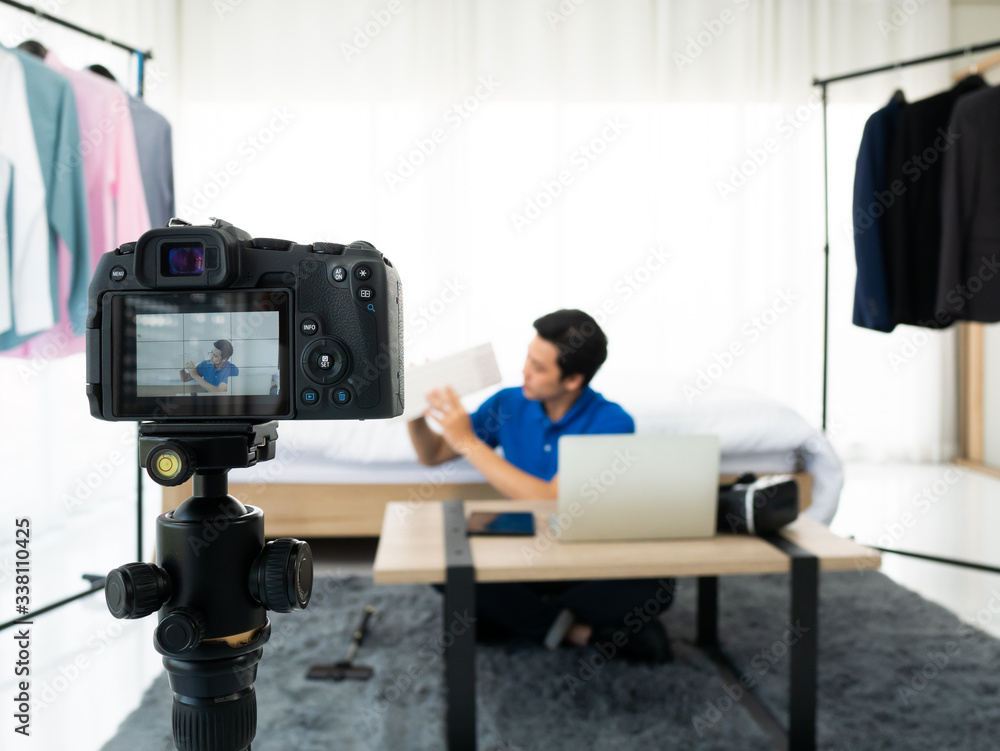 Asian blogger man promote and review gadget technology device such as virtual reality, keyboard and notebook while record video for post on channel and social media setup scene in bedroom home Asian blogger man promote and review gadget technology device such as virtual reality, keyboard and notebook while record video for post on channel and social media setup scene in bedroom home