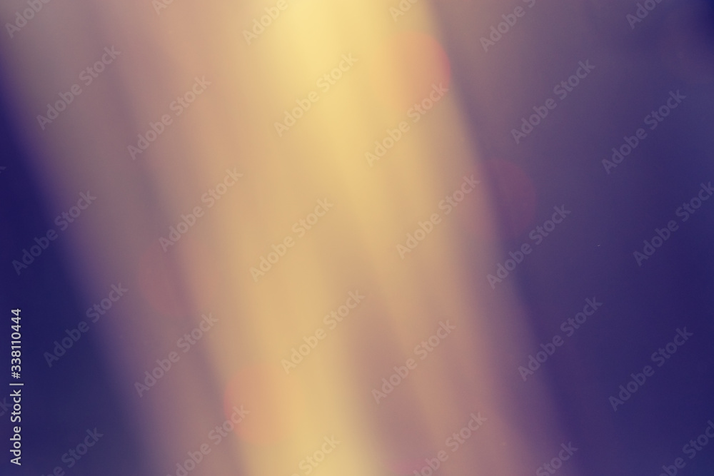 Yellow sun beams on classic blue background. Bright defocused image with light pours from window.