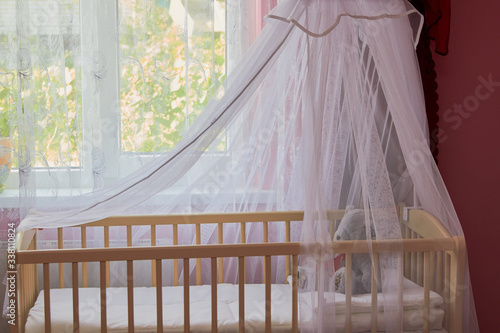 Fototapeta Naklejka Na Ścianę i Meble -  baby cradle by the window,arrangement of the baby room before the baby is born