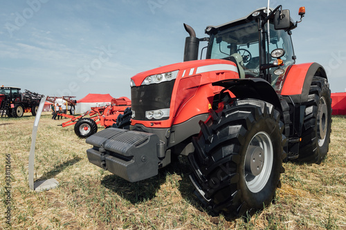 red tractor in a field at an agricultural exhibition in summer