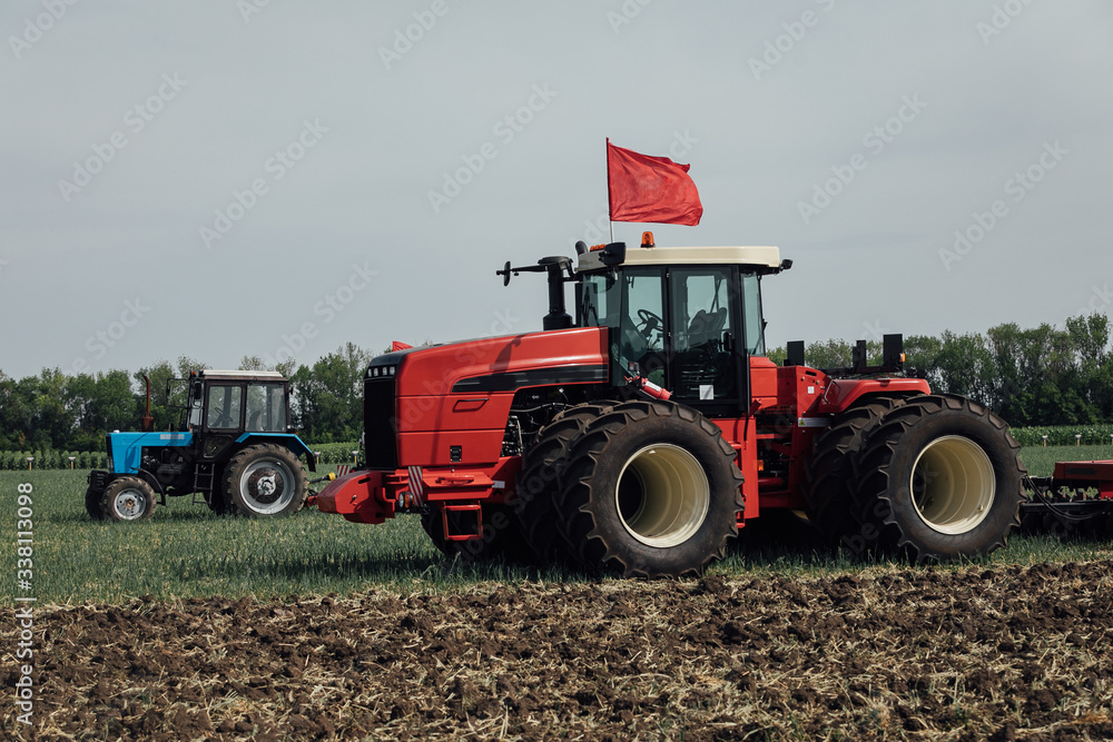 red tractor with large wheels in the field during tests during the exhibition red tractor with large wheels in the field during tests during the exhibition