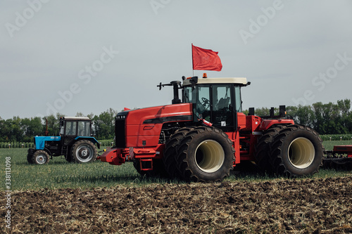 red tractor with large wheels in the field during tests during the exhibition © dobrovizcki