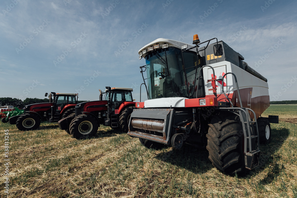 Obraz premium white red harvester on a sunny day in a field