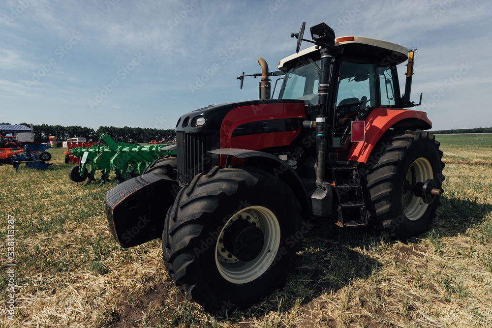 red tractor with large wheels in the field during tests during the exhibition red tractor with large wheels in the field during tests during the exhibition