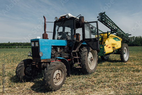 big blue tractor with big wheels in a field in summer at an agricultural exhibition