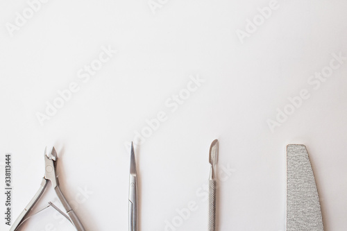  manicure set on a white background: scissors, pusher, nail file, tongs. professional pedicure tool.