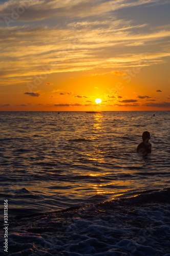 Fototapeta Naklejka Na Ścianę i Meble -  Amazing sea sunset on the pebble beach, the sun, waves, clouds