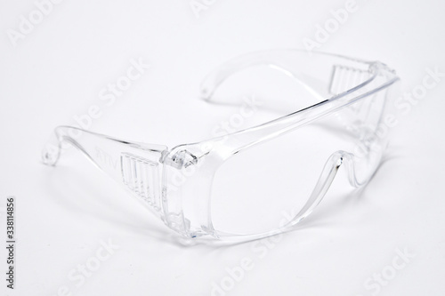 Protective transparent plastic glasses on white background