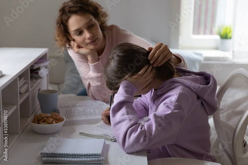 Tableau sur toile Loving mother supporting tired teenage daughter study together at home