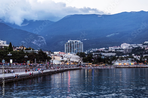 View of the evening embankment in Yalta with crowds of walking tourists. Crimea, Russia