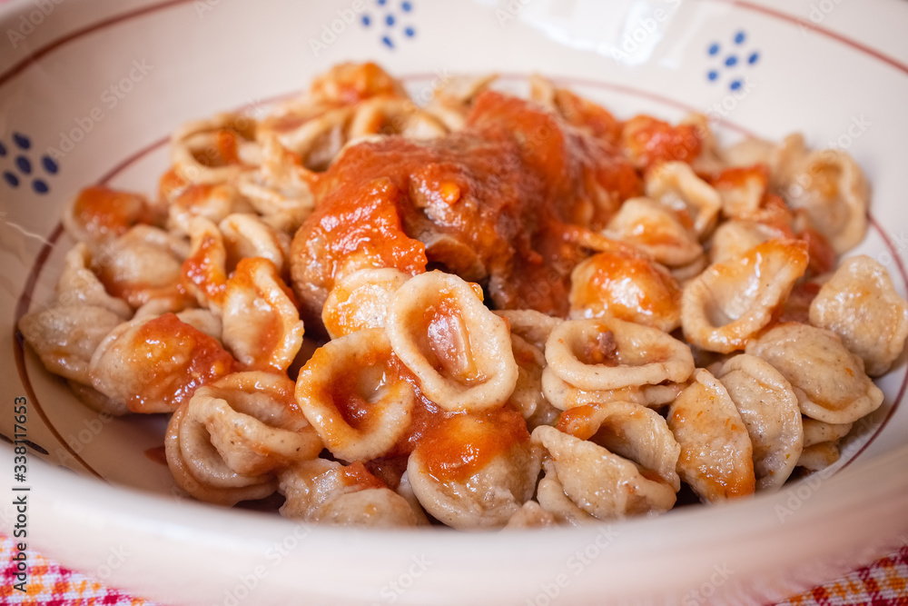 Delicious dish made of fresh pasta orecchietta and meat roll braciola with tomato sauce. Apulia typical food. Italy