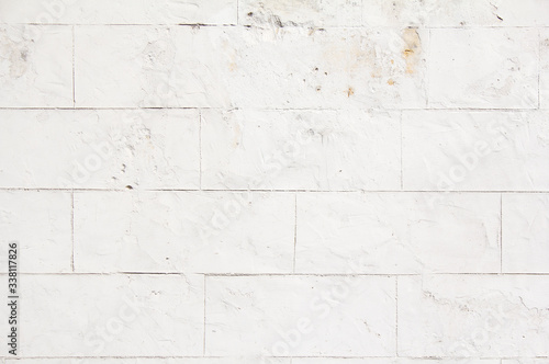 Old white stone wall with dirty spots and stains and peeling paint texture background.