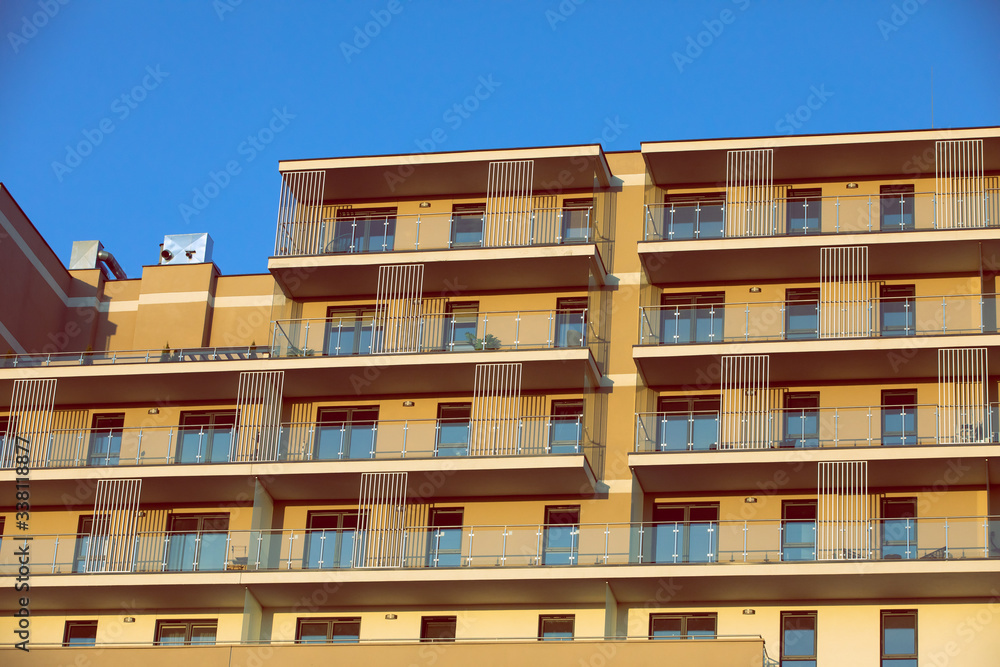 A high multi-family apartment block against a blue sky. A high multi-family apartment block against a blue sky.