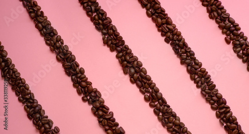 Coffee beans diagonal stripes on pink background. Top view photo