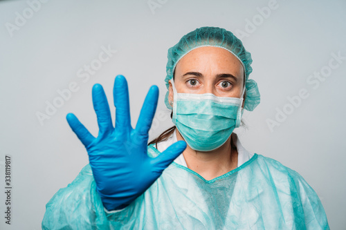 Young woman stop hand gesture, wearing medical mask protect herself from coronavirus, medical and health concept.