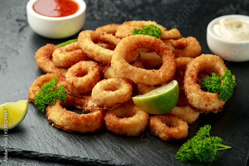 Oven baked breaded calamari rings served with lime wedges, sweet chilli sauce and mayonnaise photo