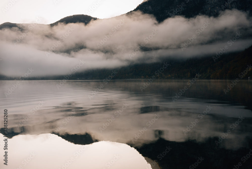 Misty morning on a mountain lake. High mountains with glacier, cold lake and fog.