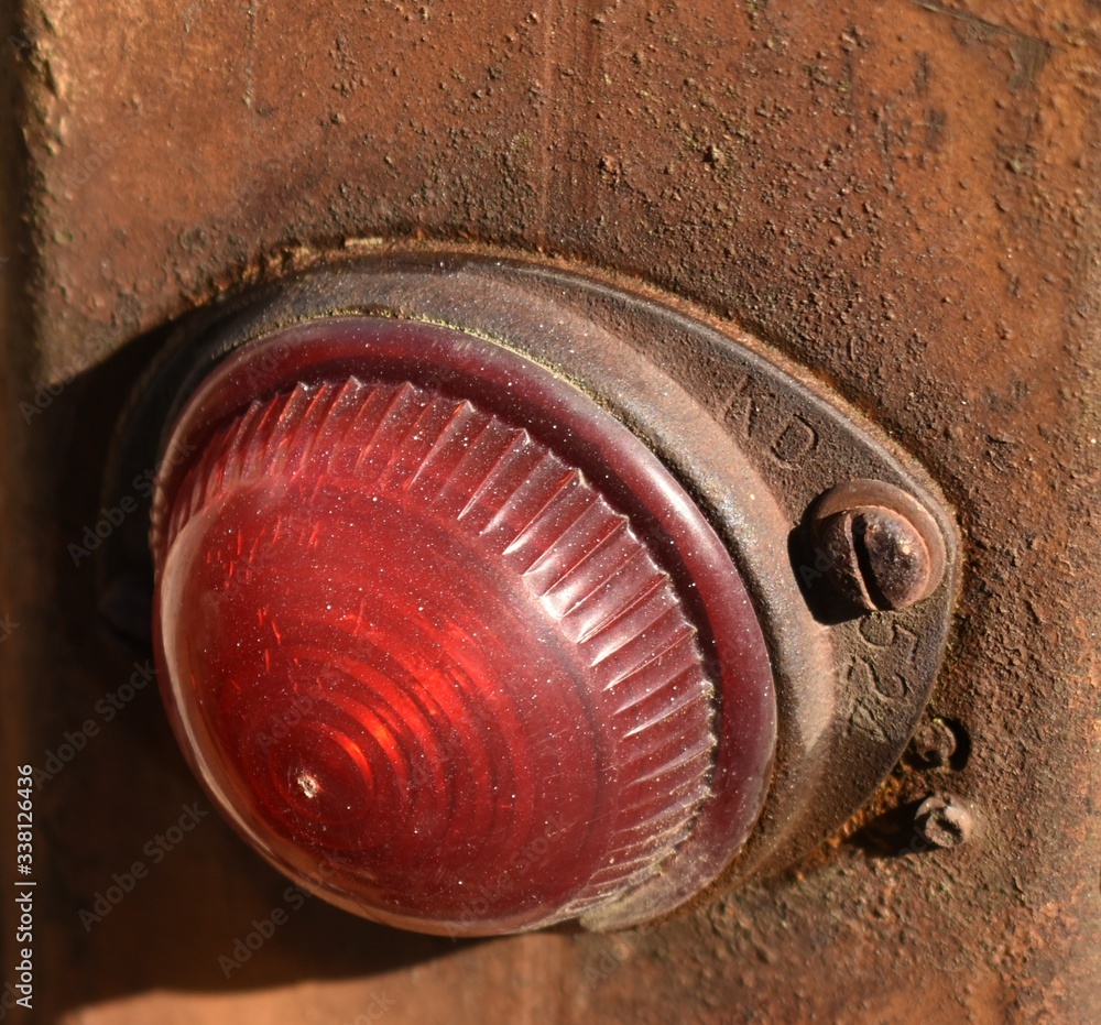 Red taillight cover on rusty metal wall