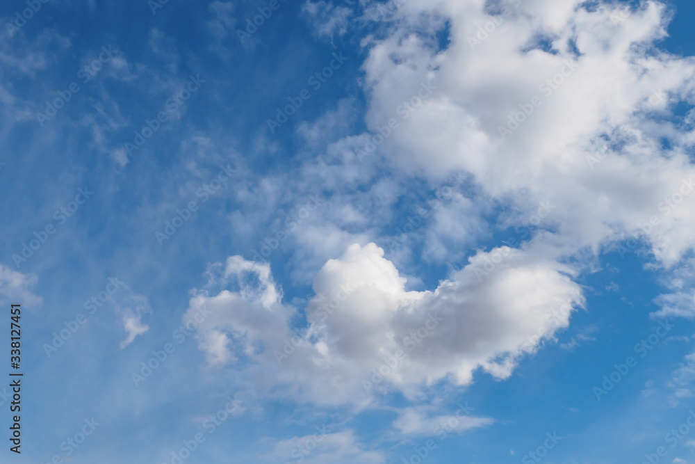 Cumulus clouds on blue sunny spring sky, nature background.