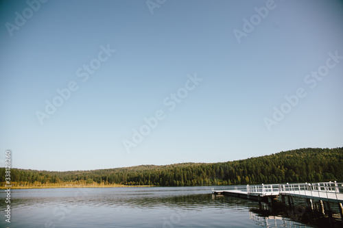  river, blue sky, sunny summer day, white pier by the river © Sergey