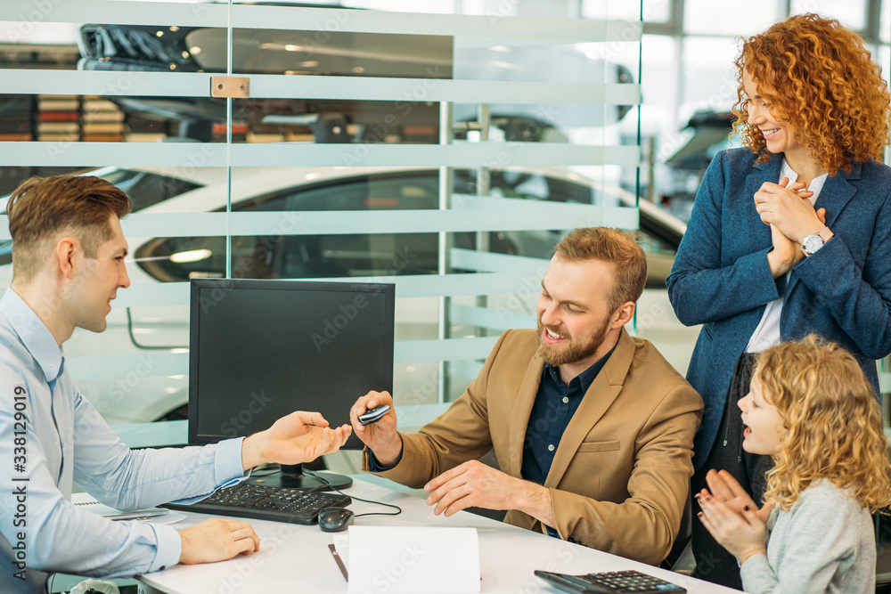 Obraz premium young caucasian couple sign a contract of buying new car in dealership, sit at table with consultant