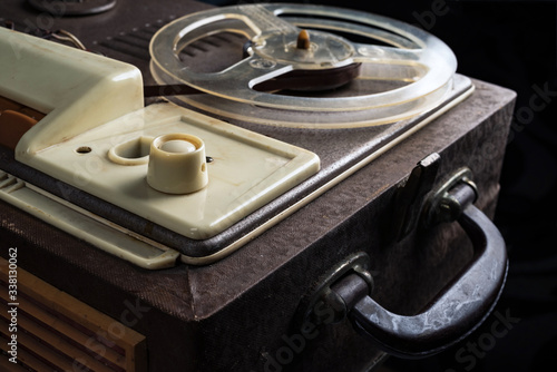 A part of vintage reel tape recorder from 1960s on a black background. Selective focus.