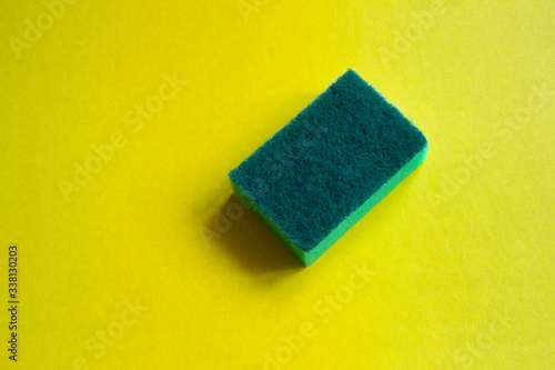 Green sponge on a yellow background