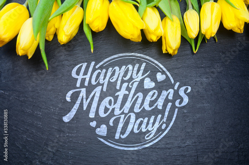 Happy Mother's Day! Flat lay yellow tulips on black background