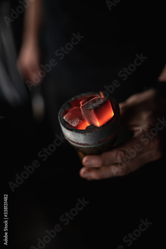 hot red coals with hookah sparks in metal bowl for Shisha Smoking Coal for hookah close-up  hot red coals for hookah in Cup close up photo