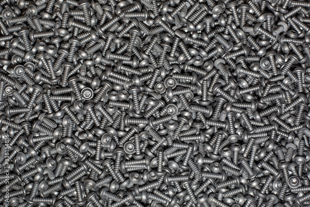 A lot of tapping metal or iron screws, screws as a background, wallpaper or texture, industrial background and concept A lot of tapping metal or iron screws, screws as a background, wallpaper or texture, industrial background and concept