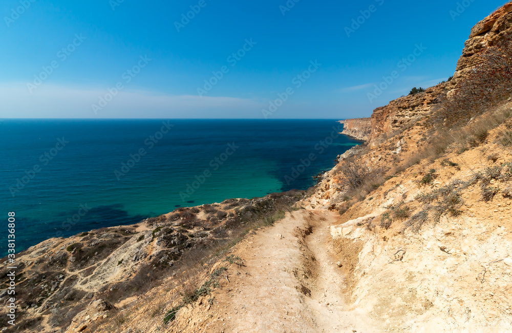 Mountain path on the rocky shore of the turquoise sea. Cape Fiolent, Sevastopol