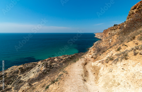 Mountain path on the rocky shore of the turquoise sea. Cape Fiolent, Sevastopol