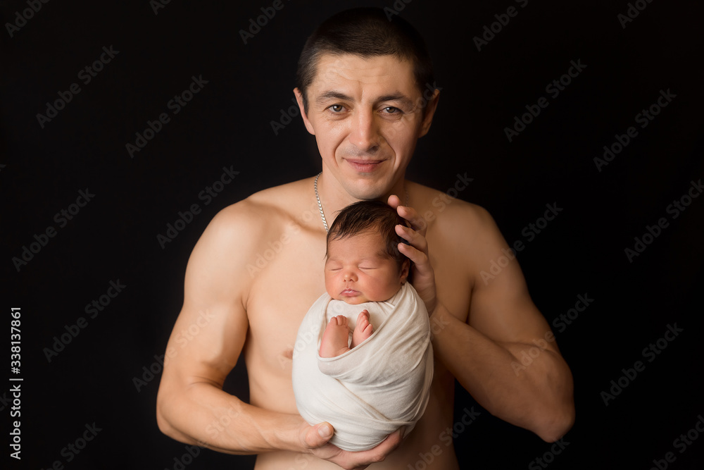 a newborn baby in the hands of his father. small child first photo shoot a newborn baby in the hands of his father. small child first photo shoot