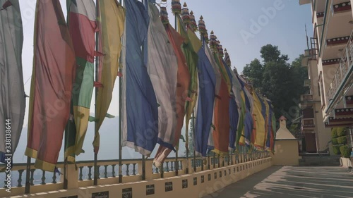 Colorful Flags Waving In The Air In Front Of Triten Norbutse Monastery In Kathmandu, Nepal On A Bright Foggy Day - Panning Shot photo