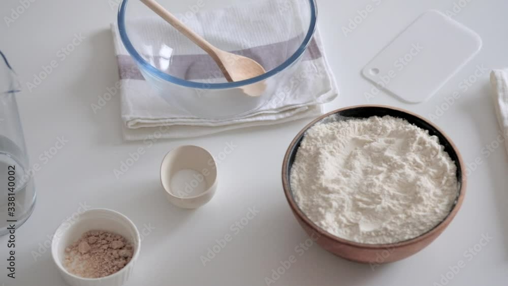 Shot of ingredients laid out for making bread. Water, salt, flour and yeast. Shot of ingredients laid out for making bread. Water, salt, flour and yeast.